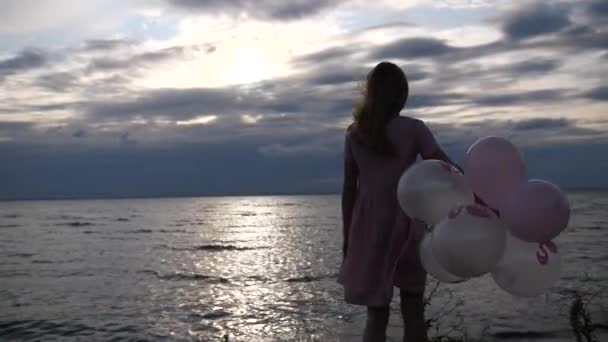 Panorama. Fille avec des boules sur un fond de soleil couchant ciel et mer. Mo lent 4K — Video