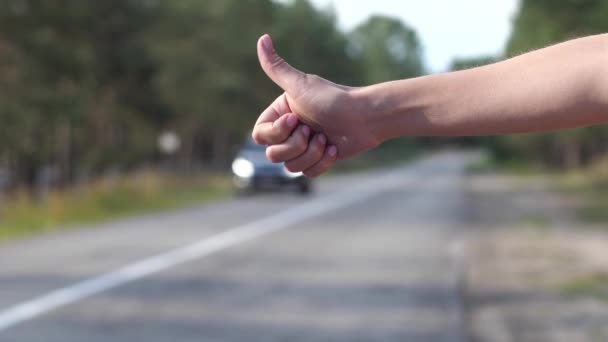 Road. A woman is trying to stop a passing car. A close-up of the hand that appears in the frame. 4K Slow Mo — Stock Video