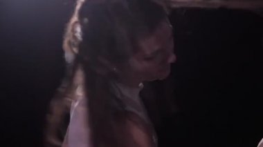 Yakın plan. Dansçı başını çevirir, koyu renk saçlar yana saçılır. 4k Ağır çekim