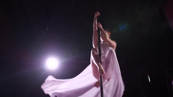 Una ballerina balla su un pilone in uno studio buio, si toglie la gonna e la lancia alla telecamera. 4K Lento Lu — Video Stock