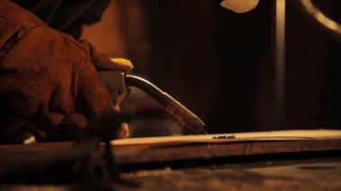 Yakın plan. Kaynak makinesi metalle çalışıyor, yangın spreyi..
