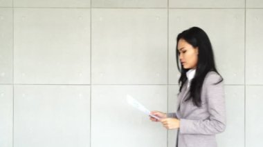 Akıllı Asyalı iş kadın ofis binasında İnceleme belgesi ile çalışma