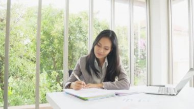 Akıllı Asyalı iş kadın ofis binasında İnceleme belgesi ile çalışma