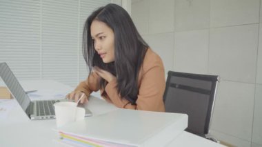 Asyalı iş kadın meşgul içinde çalışma ile Laptop Bilgisayar ve çağrı telefon için birisi