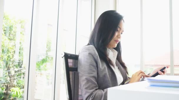 Ofis Binasında Akıllı Telefon Nceleme Belgesi Ile Çalışan Asya Kadın — Stok video