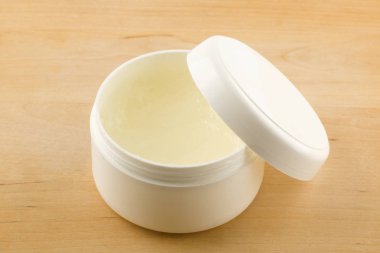 yakın çekim bir kapta beyaz tıbbi krem