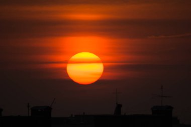 şehrin üzerinde büyük sarı güneş doğar