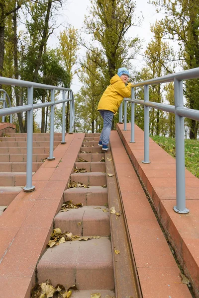 Chłopiec Żółtą Kurtkę Odpoczywa Jesienny Park — Zdjęcie stockowe