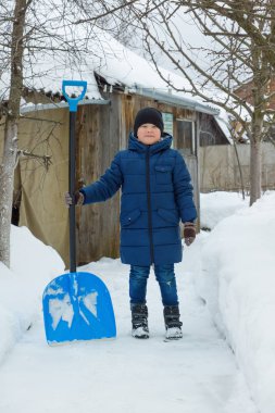 Çocuk kar büyük kürekle kışın temizler