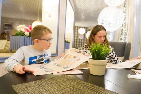 Annesi Ile Gözlüklü Çocuk Restoranda Bir Menü Seçin — Stok fotoğraf