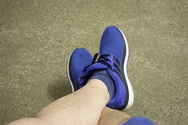 slender hairy male legs in blue sneakers