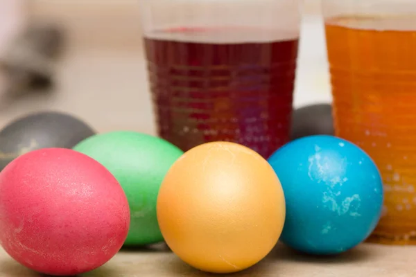 Окрашивание разноцветных пасхальных яиц в красящие растворы — стоковое фото
