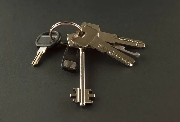 Bunch of keys to the apartment on a black background — Stock Photo, Image