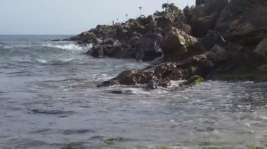 deniz iskelesi yakınındaki kayalarüzerinde kırma deniz dalgaları