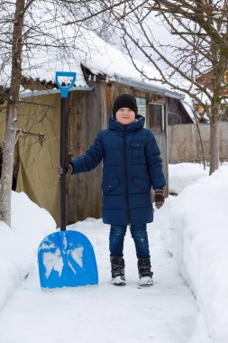 çocuk kışın bir kürek ile kar temizler