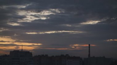 bulutlar şehrin üzerinde yükselen güneş tarafından yüzer