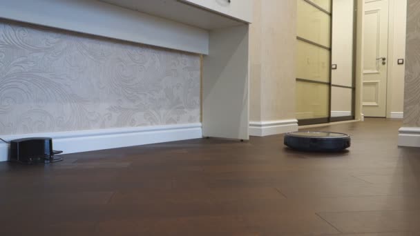 Robot Vacuum Cleaner Meninggalkan Pangkalan Dan Membersihkan Apartemen — Stok Video