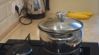bir gaz sobası üzerinde çelik tavada su kaynar