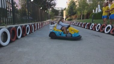 Burgaz, Bulgaristan - 23 Haziran 2016: Animatörler gözetiminde elektrikli arabalara lunaparkta yolculuk eden çocuklar.