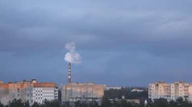 Şehrin üstündeki fabrika borusundan duman geliyor.