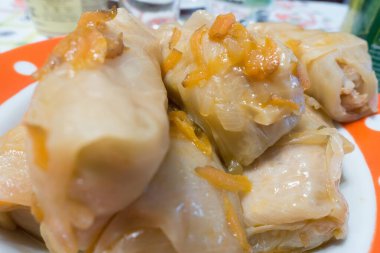 Taze ev yapımı lahana ruloları et suyunun içinde tabakta yatıyor.