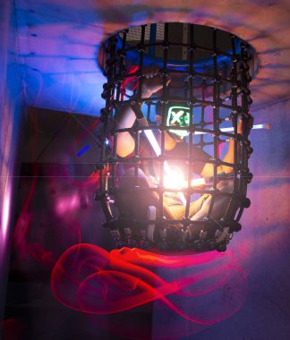 Konsept: Adam korkunç bir maske ile bir kafes içinde ışık boya ile sıkışmış.