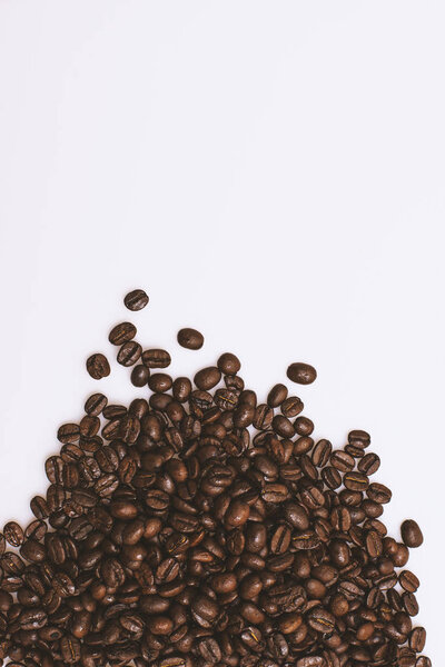 Scattered coffee beans on a white background.
