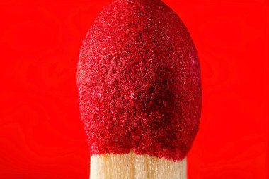 Extreme macro photo of an unburnt matchstick on a red background. Texture background. clipart