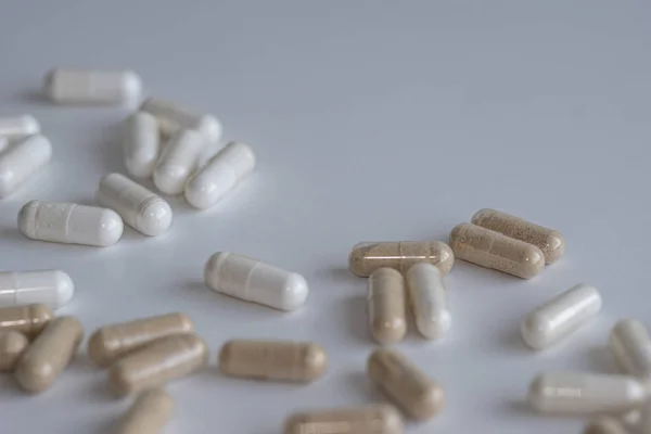 Piles of pills and capsule on white background. Selective focus