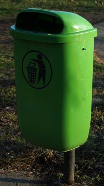 Parkta ya da bir kamu binası dışında bir yeşil plasticl çöp kutusu