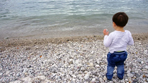 Child is playing on a rocky beach — Stock Photo, Image