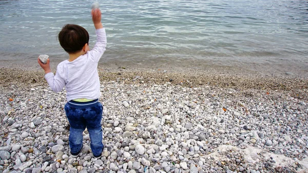 Child is playing on a rocky beach — Stock Photo, Image