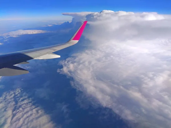 Airplane wing in the sky above the clouds