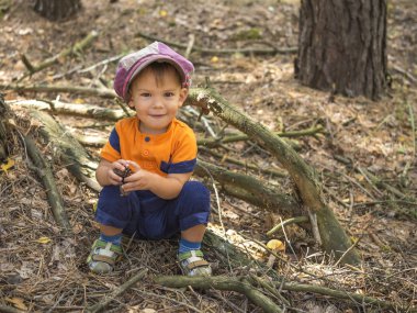 Gülümseyen yakışıklı sonbahar ormanın yakınında oturan mantar şapka.