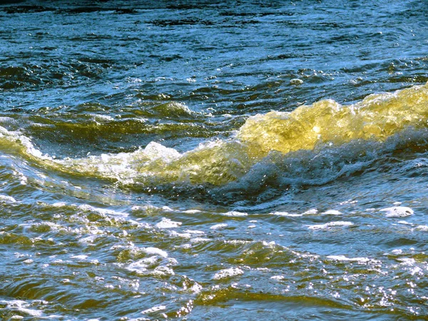 Blue yellow waves in ocean. Splashing waves.