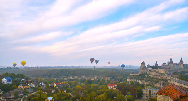 Ancient fortress and colorful hot air balloons. Kamianets-Podilskyi, Ukraine.