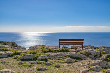 Ön plan ve bir Bank üzerinde taşlarla güzel deniz manzarası. Güneşli bir günde dinlenecek yer. Ayia Napa, Cape Greco Ulusal Forest Park, Kıbrıs.