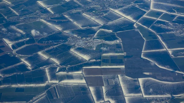 Amazing view of the snowy fields. Aerial shot from airplane window.