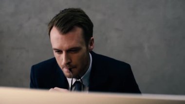 Gözlük tutan ve Office masaüstü bilgisayarla çalışma düşünceli işadamı