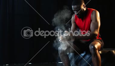 Afrika kökenli Amerikalı sporcu eğitim ağır çekimde spor salonunda önce pudra tozu ile el kapsayan