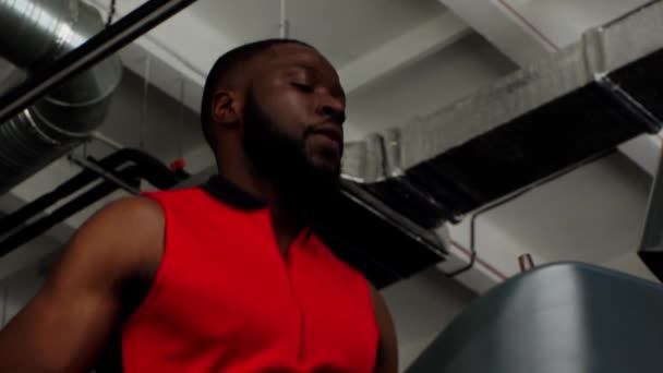 スローモーションでジムでトレッドミルで実行されているアフリカ系アメリカ人のスポーツマン — ストック動画
