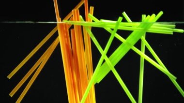 parlak renkli neon payet içine düşme berrak su siyah arka plan üzerine 