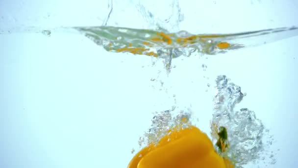 Pimentão Amarelo Brilhante Mergulhando Água Clara Fundo Azul Com Retroiluminação — Vídeo de Stock