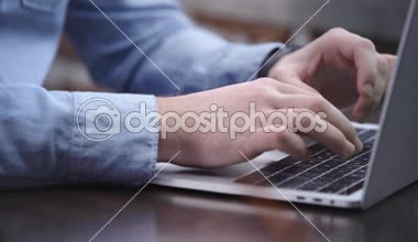 İşadamı tipik dizüstü klavye ve touchpad kullanarak mavi gömlekli kısmi görünümü