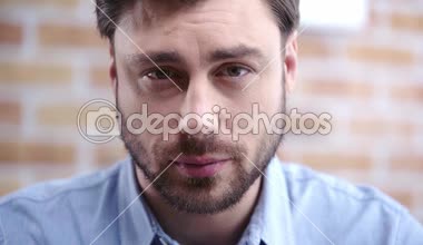 Üzgün adam aşağı bakıyor, baş hayvancılık ve kameraya bakarken yanıp sönen mavi gömlekli