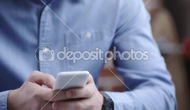 İşadamı Smartphone'da yazarak saati olan mavi gömlek konsantre 