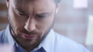 İşadamı aşağı bakıyor, yanıp sönen ve baş yetiştirme sakallı