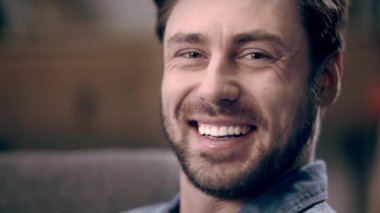 Mutlu adam gülüyor ve kameraya bakarken yanıp sönen sakallı