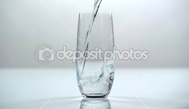 stüdyo çekimi şeffaf cam içine beyaz zemin üzerine dökülen su