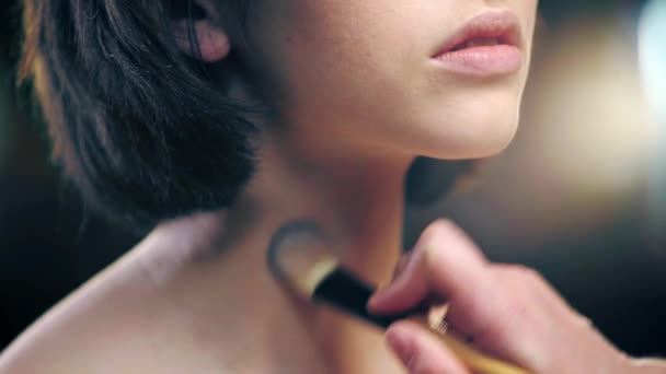 化粧品ブラシでモデルネックにファンデーションを適用するメイクアップアーティストのトリミングビュー — ストック動画
